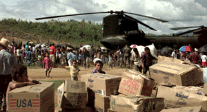 Villagers from Casamacoa, Honduras, carry relief supplies away from a U.S. Army CH-47 Chinook helicopter on Nov. 20, 1998. [Departement of Defense Photo]
