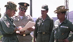 Photo still from U.S. Army film shot in 1965. U.S. military advisers confer as Col. Carlos Arana Osorio and an aide look on